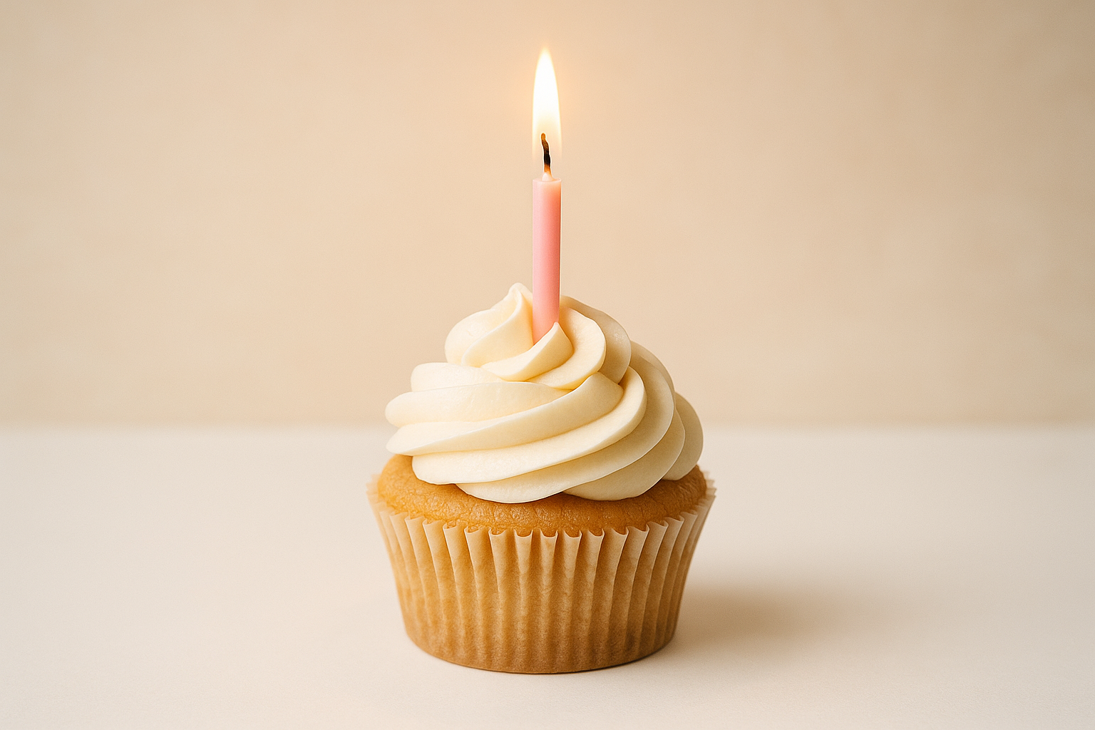 white and tan birthday cupcake with pink candle lit